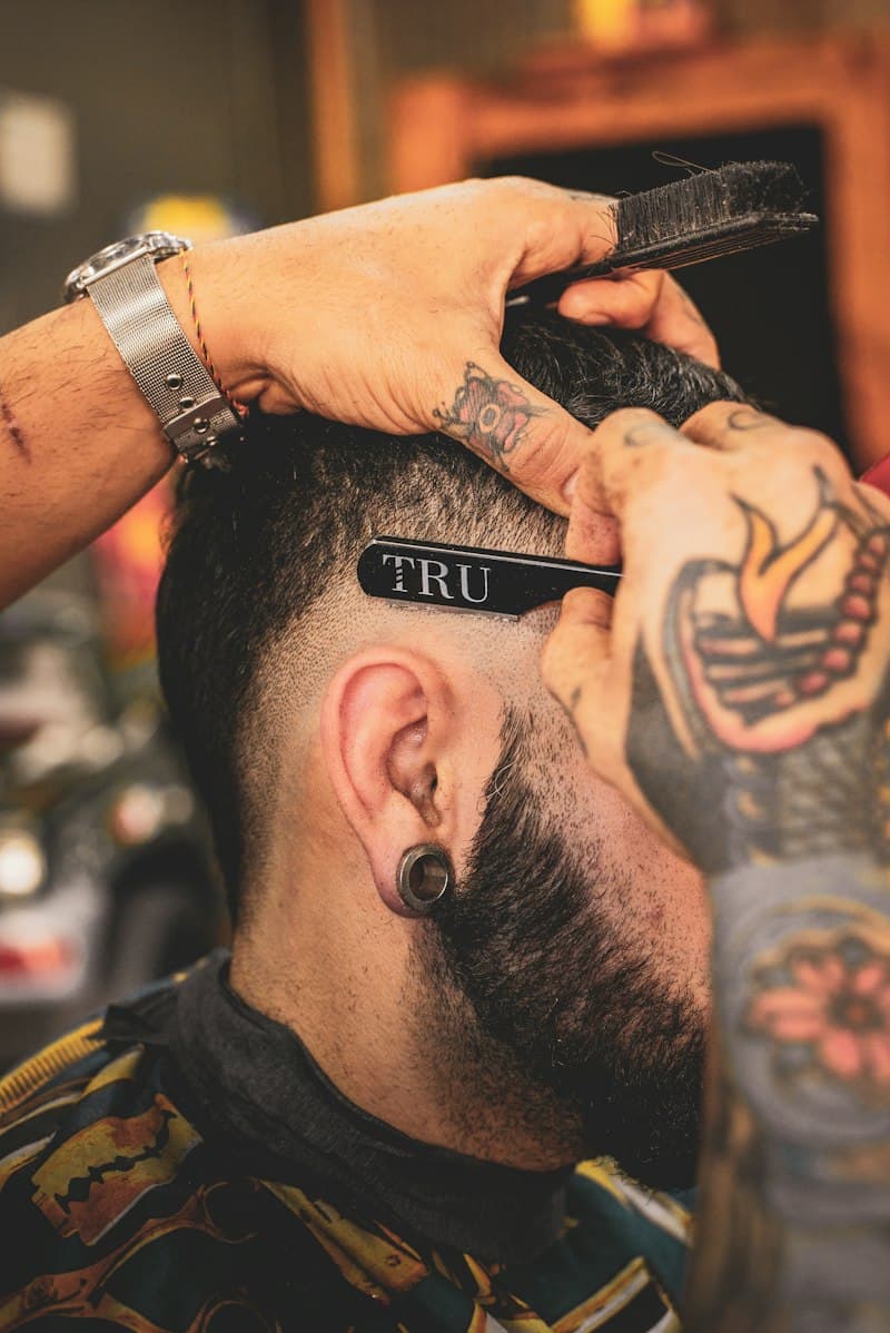 A barber shaping a fresh fade